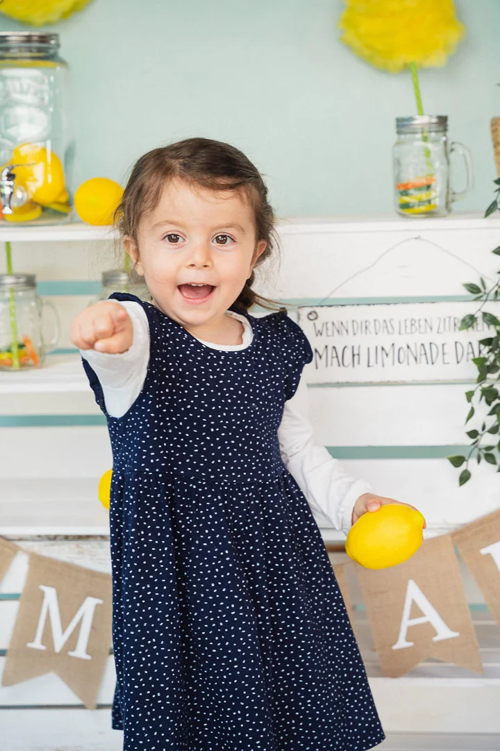 Mädchen deutet mit Zeigefinger in Richtung Kamera vom Kitafotografen in Ulm & Umgebung