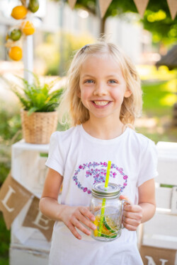 Outdoor-Kindergartenfotograf. Ein Mädchen vor einem Limoverkaufsladen in Langenau